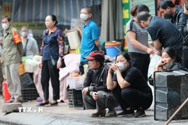 Gương mặt thất thần của người dân khi chứng kiến khu kinh doanh bị thiêu rụi. (Ảnh: Lê Đông/TTXVN)