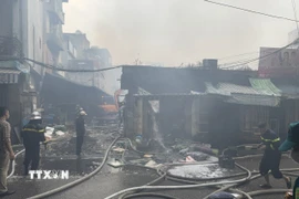 Các tổ công tác tiếp tục triển khai dập tàn và làm mát các cấu kiện để phòng ngừa cháy bùng phát trở lại. (Ảnh: Quốc Lũy/TTXVN)