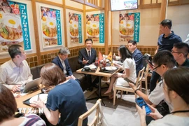 Đại sứ Việt Nam tại Nhật Bản Phạm Quang Hiệu giới thiệu với truyền thông Nhật Bản món cơm tấm Việt Nam. (Ảnh: Xuân Giao/TTXVN)