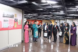 Nữ họa sỹ Văn Dương Thành giới thiệu tranh vẽ về Chủ tịch Hồ Chí Minh. (Ảnh: Phạm Tuân/TTXVN)