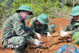 Hài cốt liệt sỹ được phát hiện ở độ sâu 1m với nhiều di vật kèm theo. (Ảnh: TTXVN phát)