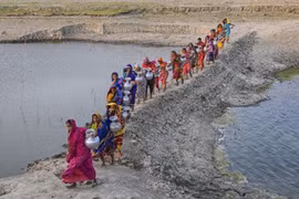 Phụ nữ tại Khulna (Bangladesh) mang nước từ nguồn nước ngọt ở xa sau khi nguồn nước uống tại địa phương bị ảnh hưởng bởi xâm nhập mặn và các vấn đề khác. (Nguồn :Getty Images)