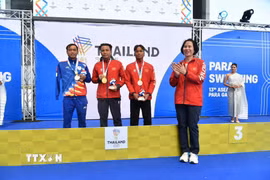 Trưởng đoàn Lê Thị Hoàng Yến trao huy chương Vàng và huy chương Đồng cho hai kình ngư Việt Nam. (Ảnh: TTXVN phát)