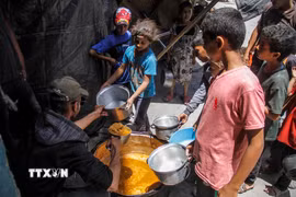Các em nhỏ nhận thực phẩm cứu trợ tại Jabalia, Dải Gaza. (Ảnh: THX/TTXVN)