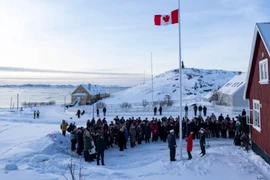Bộ trưởng Ngoại giao Anita Anand, ở vị trí trung tâm phía trước, giúp kéo cờ Canada tại lãnh sự quán Canada mới ở Nuuk, Greenland. (Ảnh: The Canadian Press/AP)
