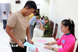 Thành viên Tổ bầu cử số 6 (xã Cà Ná) phát phiếu bầu cho cư tri thực hiện quyền công dân của mình. (Ảnh: Công Thử/TTXVN)