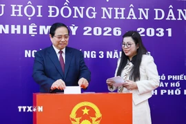 Thủ tướng Phạm Minh Chính và Phu nhân bỏ phiếu bầu tại Khu vực bỏ phiếu số 21, phường Tây Hồ, thành phố Hà Nội. (Ảnh: Dương Giang/TTXVN)