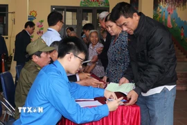 Hướng dẫn cử tri bầu cử tại khu vực bầu cử 2, phường Hồng Châu (tỉnh Hưng Yên). (Ảnh: Nguyễn Công Hải/\TTXVN)