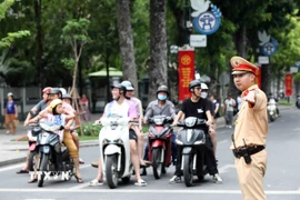 Lực lượng cảnh sát giao thông tổ chức điều tiết, phân luồng giao thông tại các nút giao thông trọng điểm đảm bảo an toàn giao thông thông suốt. (Ảnh: Phạm Kiên/TTXVN)