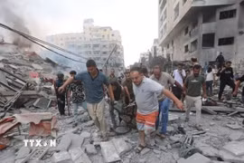 Chuyển thi thể nạn nhân sau các cuộc không kích của Israel xuống Dải Gaza. (Ảnh: IRNA/TTXVN)