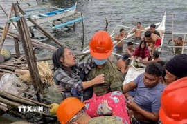Các binh sỹ hỗ trợ người dân di chuyển khi bão Bualoi đổ bộ vào tỉnh Samar, Philippines ngày 26/9/2025. Ảnh: THX/TTXVN)