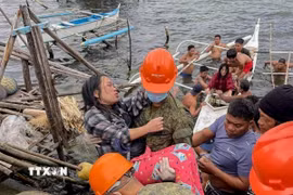 Các binh sỹ hỗ trợ người dân di chuyển khi bão Bualoi đổ bộ vào tỉnh Samar, Philippines ngày 26/9/2025. Ảnh: THX/TTXVN)
