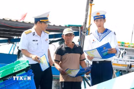 Cán bộ, chiến sỹ Lữ đoàn 681, Vùng 2 Hải quân, tuyên truyền cho ngư dân về phòng chống vi phạm khai thác hải sản bất hợp pháp, không báo cáo và không theo quy định (IUU). (Ảnh: Nguyễn Thanh/TTXVN)