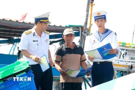 Cán bộ, chiến sỹ Lữ đoàn 681, Vùng 2 Hải quân, tuyên truyền cho ngư dân về phòng chống vi phạm khai thác hải sản bất hợp pháp, không báo cáo và không theo quy định (IUU). (Ảnh: Nguyễn Thanh/TTXVN)