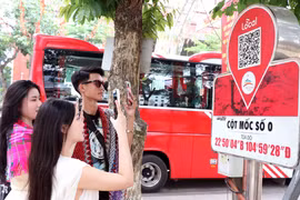 Du khách quét QR tại Km0 Hà Giang tìm hiểu thông tin du lịch. (Ảnh: Đức Thọ/TTXVN)