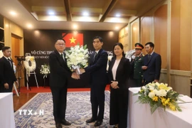 Phó Thủ tướng Thái Lan Prasert Jantararuangtong trao Đại sứ Phạm Việt Hùng vòng hoa của Thủ tướng Paetongtarn Shinawatra gửi viếng nguyên Chủ tịch nước Trần Đức Lương. (Ảnh: Đỗ Sinh/TTXVN)