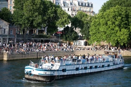 Người dân tránh nóng tại sông Seine ở Paris, Pháp. (Ảnh: THX/TTXVN)