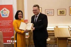 Pavel Bolshkov trao cuốn sách cho Phó Giám đốc bảo tàng Hồ Chí Minh Đỗ Thị Thu Hằng. (Ảnh: Tâm Hằng/TTXVN)