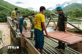 Người dân và chính quyền đã kịp thời khắc phục sự cố đầu Cầu Sơn Thủy trên Quốc lộ 16 tại lý trình Km89+580 tại bản Chung Sơn bị hư hỏng nặng chân, mố cầu, và bị sập hoàn toàn mặt đường nhựa dài hơn 10 mét. (Ảnh: TTXVN phát)