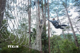 Tham gia những trò chơi mạo hiểm mang tính thử thách cao (High Rope Course), đòi hỏi người chơi phải có thể lực và sự quyết tâm mới có thể hoàn thành hành trình. (Ảnh: Hoàng Hiếu/TTXVN)