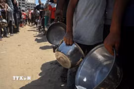 Người dân chờ được phát thực phẩm cứu trợ tại trại tị nạn al-Shati, Gaza. (Ảnh: THX/TTXVN)