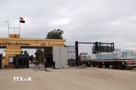 Xe chở hàng viện trợ nhân đạo đi qua cửa khẩu Rafah. (Ảnh: THX/TTXVN)