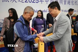 Các hành khách trên chuyến bay DZ6355 được lãnh đạo thành phố Huế trao hoa và tặng quà lưu niệm chúc mừng. (Ảnh: Văn Dũng/TTXVN)