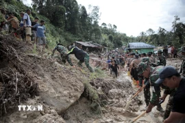 Lực lượng cứu hộ và người dân thu dọn bùn đất sau lũ lụt và lở đất tại Bắc Sumatra, Indonesia, ngày 28/11/2025. (Ảnh: THX/TTXVNc)