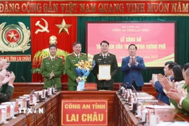 Chủ tịch Ủy ban Nhân dân tỉnh Lai Châu, Hà Quang Trung tặng hoa và trao thư khen của Thủ tướng Chính phủ cho Ban Giám đốc Công an tỉnh Lai Châu. (Ảnh: Quý Trung/TTXVN)