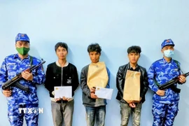 Lực lượng chức năng bắt giữ các đối tượng. (Ảnh: TTXVN phát)