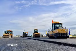 Thi công thảm bê tông nhựa trên tuyến chính cao tốc đoạn qua địa bàn phường Vĩnh Tế, tỉnh An Giang. (Ảnh: Thanh Sang/TTXVN)