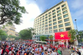 Người dân tập trung trước cổng TTXVN theo dõi truyền hình trực tiếp Lễ diễu binh, diễu hành kỷ niệm 80 năm Quốc khánh. (Ảnh: Nhật Anh/TTXVN)