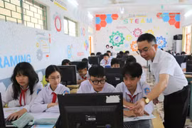 Thầy Nguyễn Chí Thanh, Giáo viên Trường THCS Nguyễn Bỉnh Khiêm, xã Vĩnh Bảo hướng dẫn học sinh làm bài tập môn Tin học. (Ảnh: Minh Thu/TTXVN)
