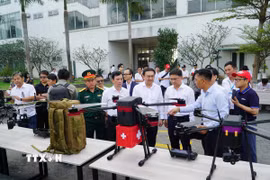 Các đại biểu tham qua khu vực trưng bày UAV tại chương trình. (Ảnh: Thu Hoài/TTXVN)