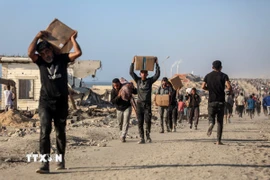 Người dân Palestine nhận hàng viện trợ tại thành phố Gaza. (Ảnh: THX/TTXVN)