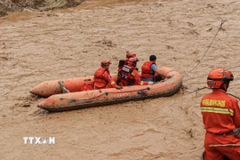Lực lượng cứu hộ làm nhiệm vụ tại khu vực ngập lụt ở Khánh Dương, tỉnh Cam Túc (Trung Quốc). (Ảnh: THX/TTXVN)