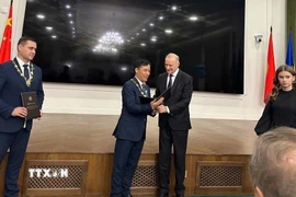 Chủ tịch IAAS, Viện sỹ Viện hàn lâm khoa học Belarus ông Vladimir Gusakov trao bằng Viện sỹ cho Giáo sư, Viện sỹ Lê Trường Giang. (Ảnh: Tâm Hằng/TTXVN)