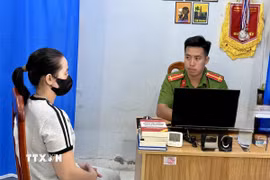 Công an xã Núi Cấm, An Giang, làm việc với bà T.T.T.N (sinh năm 1988) người trình báo cá sấu xuất hiện trên kênh Vịnh Tre. (Ảnh: TTXVN phát)