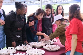 Các thành viên thích thú với sản phẩm nem chay rán do chính tay mình làm từ sơ chế đến cuốn nem. (Ảnh: Hồng Minh/TTXVN)