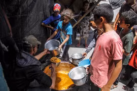 Các em nhỏ nhận thực phẩm cứu trợ tại Jabalia, Dải Gaza. (Ảnh: THX/TTXVN)