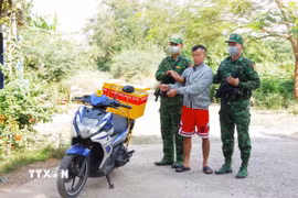 Đối tượng Trình Văn Thông (giữa) cùng phương tiện vận chuyển hơn 22 kg ma túy từ Campuchia về Việt Nam. (Ảnh: TTXVN phát)