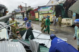 Các lực lượng, chính quyền xã giúp người dân dọn dẹp nhà bị sập, tốc mái ở xã Hoằng Giang. (Ảnh: Việt Hoàng/TTXVN)