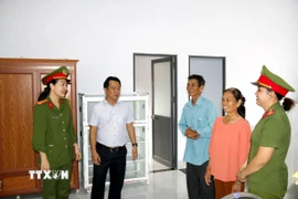 Ông Dương Thanh Vân (thứ ba bên phải sang) ở khu phố Kim Ngọc, phường Hàm Thắng vui mừng khi được nhận nhà “Chiến dịch Quang Trung”. (Ảnh: Hồng Hiếu/TTXVN)