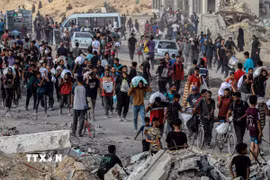 Người dân Palestine nhận hàng cứu trợ tại Gaza. (Ảnh: THX/TTXVN)