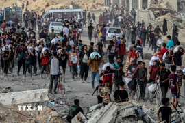 Người dân Palestine nhận hàng cứu trợ tại Gaza. (Ảnh: THX/TTXVN)