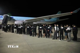 Các công dân Hàn Quốc liên quan hoạt động lừa đảo sử dụng công nghệ được bàn giao tại sân bay quốc tế ở thủ đô Phnom Penh, Vương quốc Campuchia, tối 17/10/2025. (Ảnh: AKP/TTXVN phát)