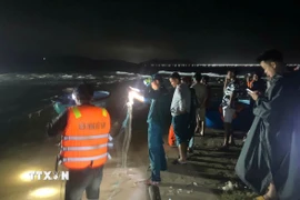 Lực lượng chức năng xuyên đêm tìm kiếm các nạn nhân. (Ảnh: TTXVN phát)