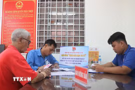 Lực lượng đoàn viên, thanh niên hỗ trợ người dân sử dụng ứng dụng VNeID trong giải quyết thủ tục hành chính. (Ảnh: Hồng Thái/TTXVN)