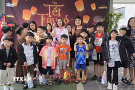 Ban tổ chức chụp ảnh kỷ niệm với các cháu thiếu nhi. (Ảnh: Đức Thắng/TTXVN)