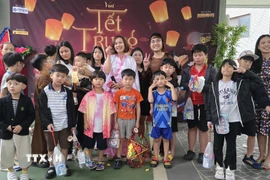 Ban tổ chức chụp ảnh kỷ niệm với các cháu thiếu nhi. (Ảnh: Đức Thắng/TTXVN)